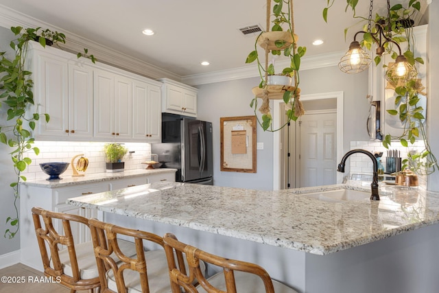 112 Sandhill Crane Dr, Lafayette, LA 70508 - kitchen with a sink, freestanding refrigerator, light stone countertops, tasteful backsplash, and recessed lighting