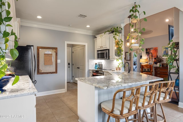 112 Sandhill Crane Dr, Lafayette, LA 70508 - kitchen featuring appliances with stainless steel finishes, a sink, a peninsula, ornamental molding, and baseboards