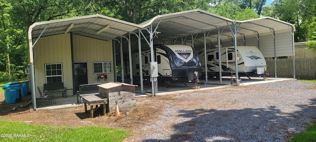 1462 Herman Dupuis Rd, Breaux Bridge, LA 70517 - view of parking featuring a detached carport, fence, and gravel driveway