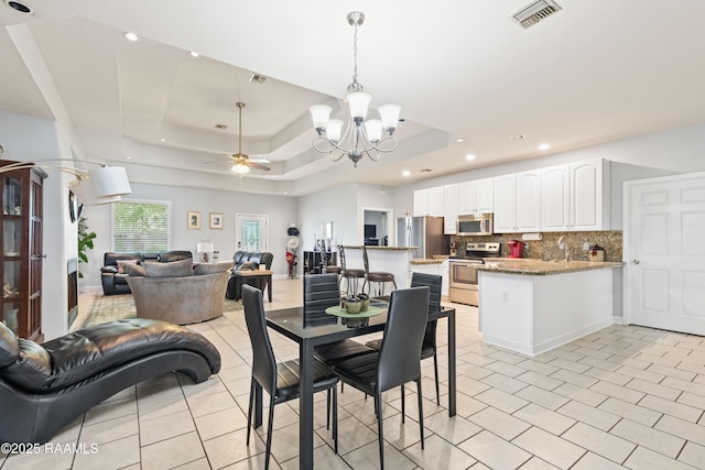 201 Rue Paon, Youngsville, LA 70592 - dining area with a chandelier, light tile patterned floors, a tray ceiling, a ceiling fan, and recessed lighting