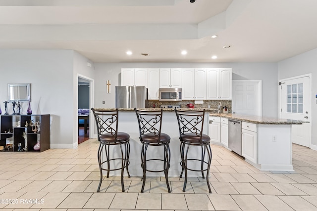 201 Rue Paon, Youngsville, LA 70592 - kitchen featuring stainless steel appliances, recessed lighting, a kitchen island, light tile patterned flooring, and tasteful backsplash