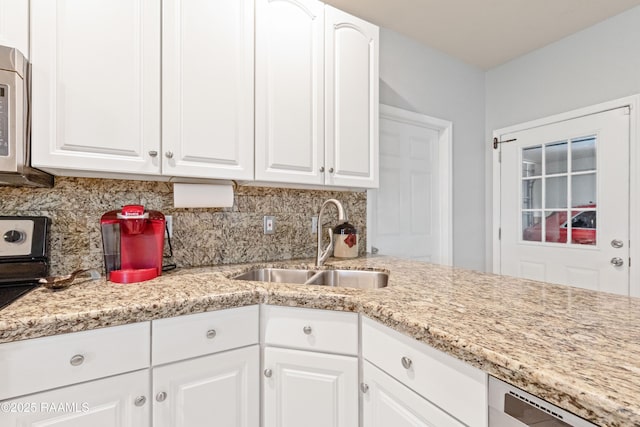 201 Rue Paon, Youngsville, LA 70592 - kitchen featuring a sink, backsplash, dishwashing machine, white cabinetry, and light stone counters