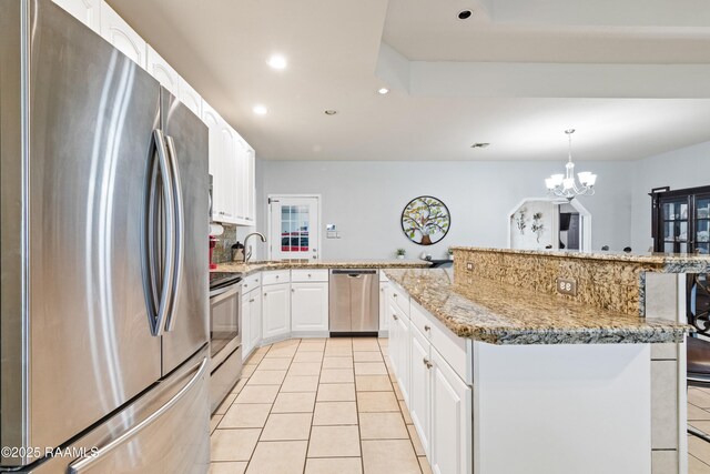 201 Rue Paon, Youngsville, LA 70592 - kitchen featuring appliances with stainless steel finishes, recessed lighting, light tile patterned floors, light stone counters, and white cabinets