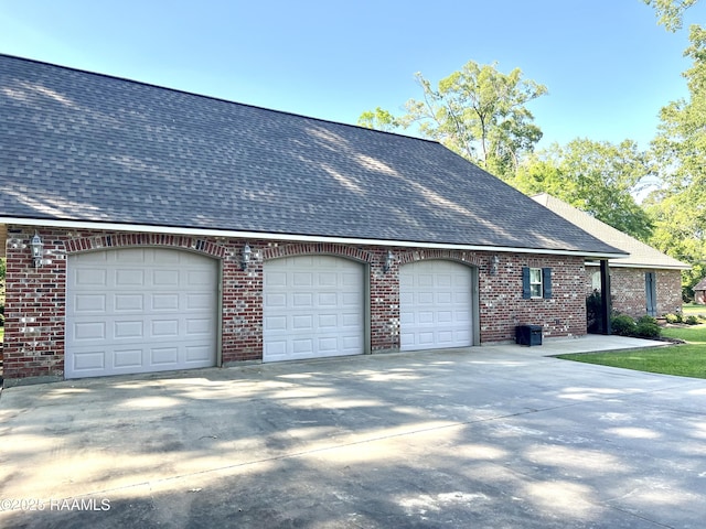 277 Carrera Ln, Eunice, LA 70535 - view of property exterior with roof with shingles, an attached garage, concrete driveway, and brick siding