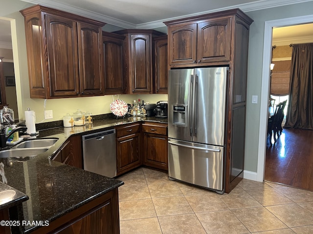 277 Carrera Ln, Eunice, LA 70535 - kitchen featuring stainless steel appliances, a sink, crown molding, dark stone counters, and light tile patterned floors