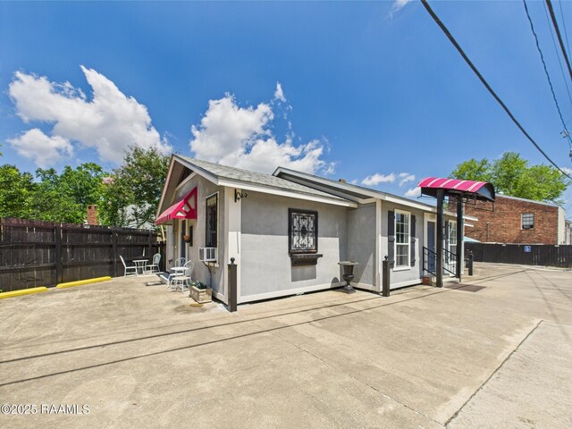 1206 Kaliste Saloom Rd, Lafayette, LA 70508 - view of front of house featuring fence, a patio, stucco siding, and cooling unit