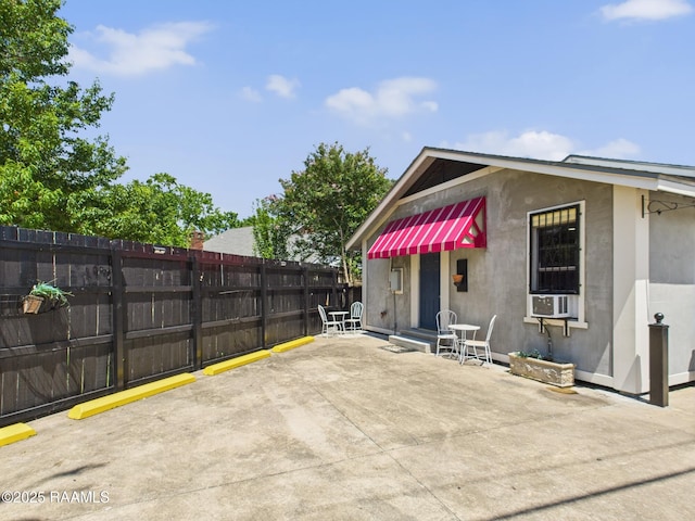1206 Kaliste Saloom Rd, Lafayette, LA 70508 - rear view of house with fence, stucco siding, a patio area, and uncovered parking