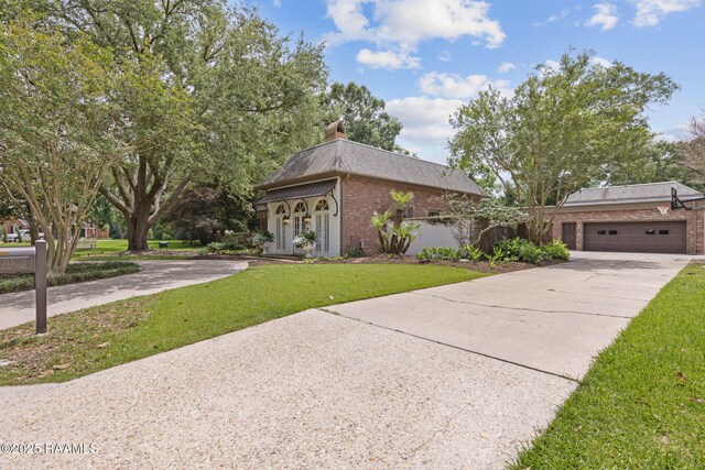 315 Kings Rd, Lafayette, LA 70503 - view of front of property with brick siding, concrete driveway, a front yard, an attached garage, and a chimney