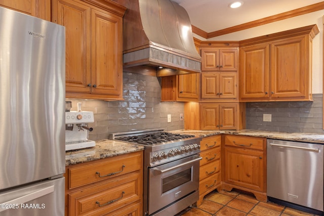 315 Kings Rd, Lafayette, LA 70503 - kitchen featuring stainless steel appliances, custom range hood, ornamental molding, decorative backsplash, and light stone countertops