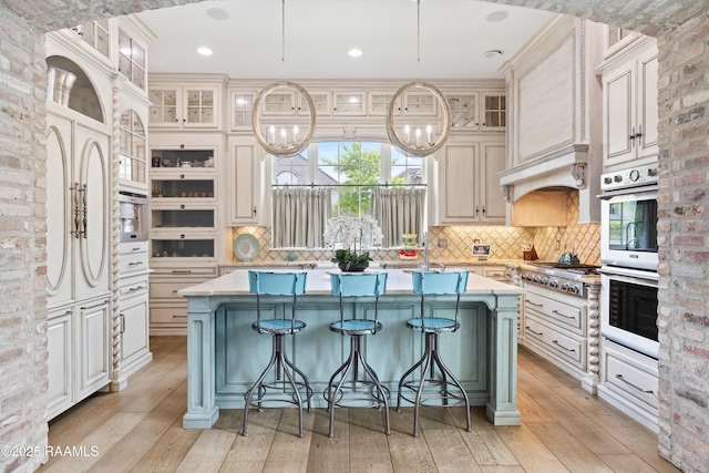 408 Princeton Woods Loop, Lafayette, LA 70508 - kitchen with stainless steel double oven, a center island, light wood finished floors, decorative backsplash, and recessed lighting