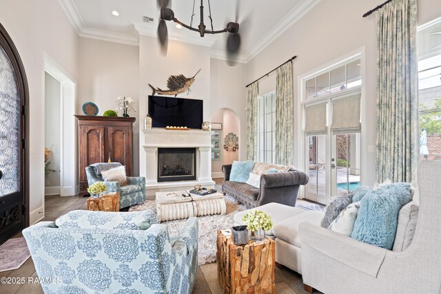 408 Princeton Woods Loop, Lafayette, LA 70508 - living area featuring ornamental molding, wood finished floors, a chandelier, a high ceiling, and a glass covered fireplace