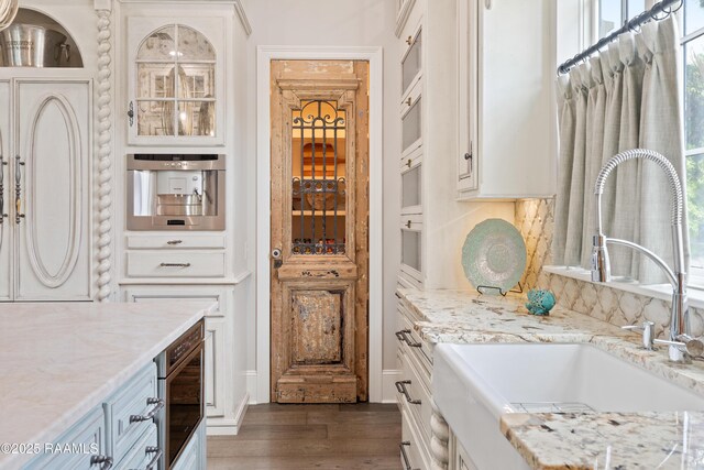 408 Princeton Woods Loop, Lafayette, LA 70508 - kitchen with dark wood-type flooring, light stone countertops, white cabinets, and glass insert cabinets
