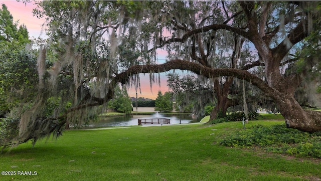 408 Princeton Woods Loop, Lafayette, LA 70508 - yard at dusk with a water view and a lawn