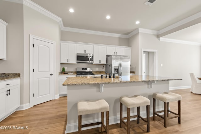 101 Micah Edward, Maurice, LA 70555 - kitchen with stainless steel appliances, a kitchen bar, white cabinets, an island with sink, and crown molding