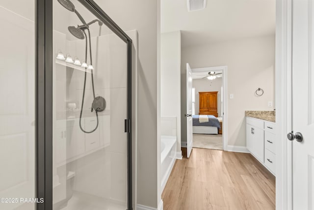 101 Micah Edward, Maurice, LA 70555 - ensuite bathroom featuring a shower stall, ceiling fan, a bath, and wood finished floors