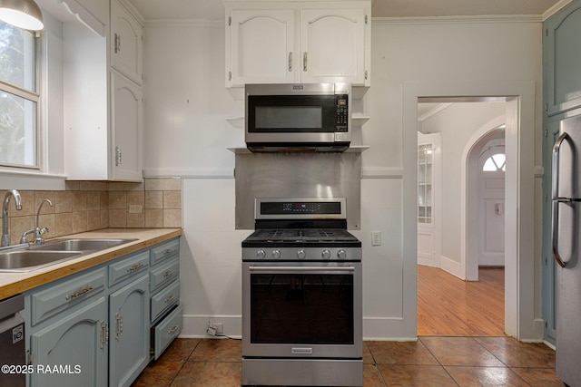 308 Boas Ave, New Iberia, LA 70563 - kitchen with stainless steel appliances, a sink, crown molding, decorative backsplash, and dark tile patterned flooring