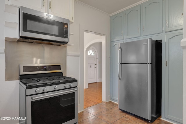 308 Boas Ave, New Iberia, LA 70563 - kitchen featuring appliances with stainless steel finishes, ornamental molding, arched walkways, and light tile patterned floors