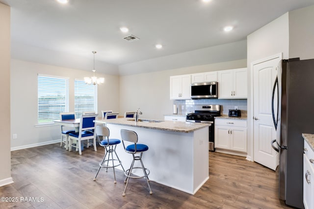 7014 Acacia Lake Dr, Maurice, LA 70555 - kitchen featuring stainless steel appliances, a sink, a kitchen island with sink, dark wood-style floors, and a chandelier