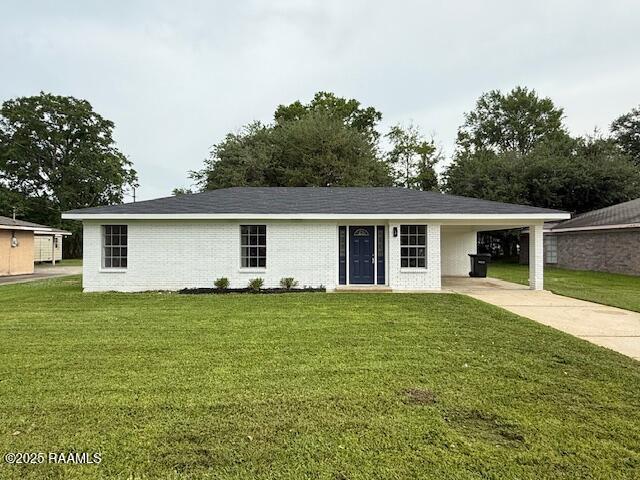 ranch-style house with driveway, an attached carport, a front lawn, and brick siding