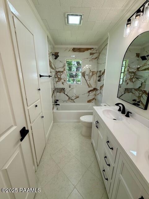 bathroom featuring bathing tub / shower combination, toilet, vanity, ornamental molding, and tile patterned flooring