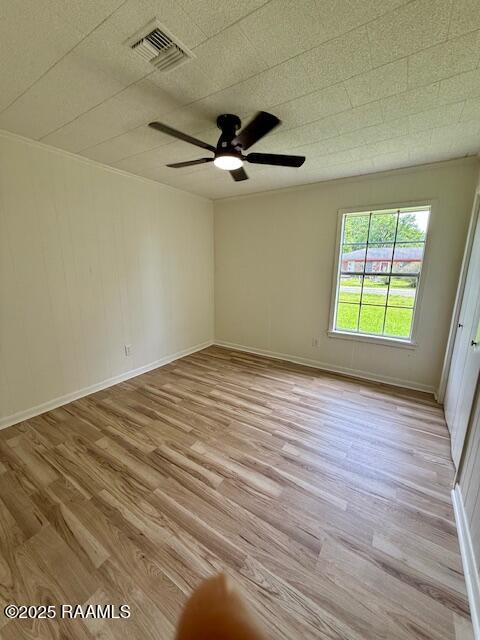spare room with light wood-style floors, a ceiling fan, and baseboards