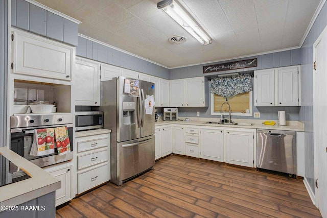 1005 Tensas Dr, Opelousas, LA 70570 - kitchen with appliances with stainless steel finishes, ornamental molding, a sink, light countertops, and white cabinets