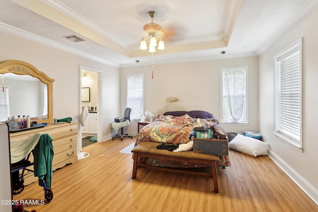 4306 Holly Dr, Slidell, LA 70461 - bedroom with light wood-style flooring, ornamental molding, a raised ceiling, connected bathroom, and ceiling fan