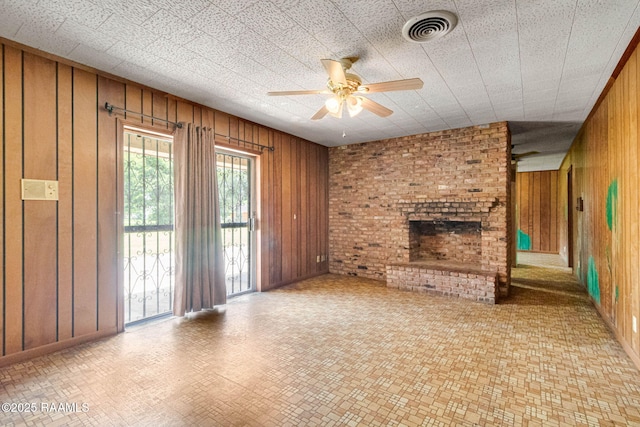 506 Rice Ln, Opelousas, LA 70570 - unfurnished living room with wooden walls, ceiling fan, a brick fireplace, and baseboards