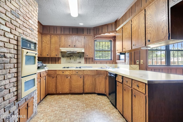 506 Rice Ln, Opelousas, LA 70570 - kitchen with black dishwasher, light countertops, double oven, brown cabinets, and a textured ceiling