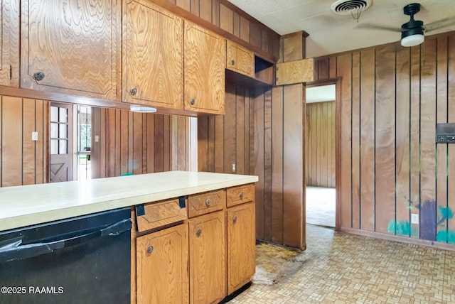506 Rice Ln, Opelousas, LA 70570 - kitchen featuring dishwasher, wood walls, light countertops, a ceiling fan, and brown cabinetry
