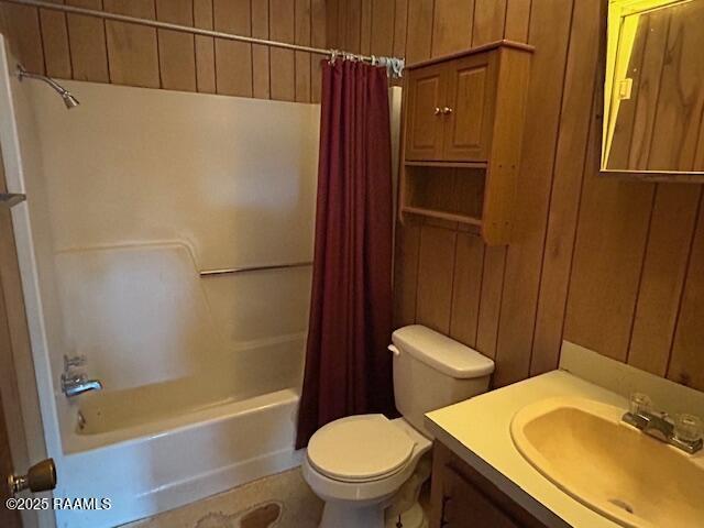 143 Monette St, Ville Platte, LA 70586 - bathroom with shower / bath combo with shower curtain, toilet, vanity, and wood walls