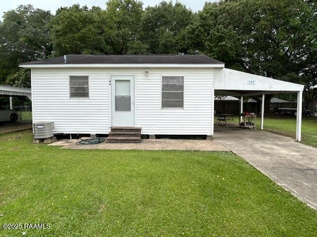 143 Monette St, Ville Platte, LA 70586 - rear view of property with entry steps, central air condition unit, a yard, driveway, and an attached carport