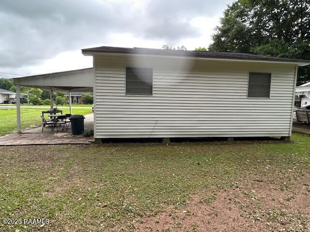 143 Monette St, Ville Platte, LA 70586 - view of side of home with a lawn and a patio