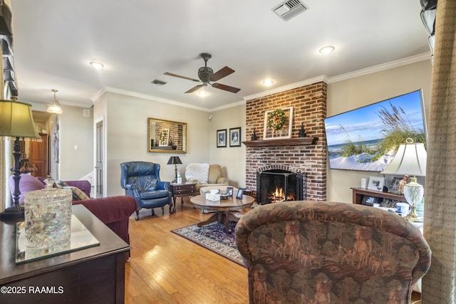 10154 Willow Crest Rd, Abbeville, LA 70510 - living room with a fireplace, a ceiling fan, wood finished floors, crown molding, and recessed lighting