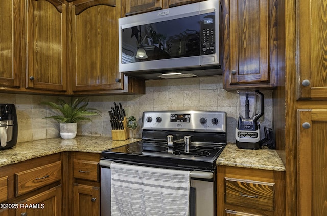 100 Mirada Ln, Lafayette, LA 70508 - kitchen with stainless steel appliances, decorative backsplash, and light stone counters