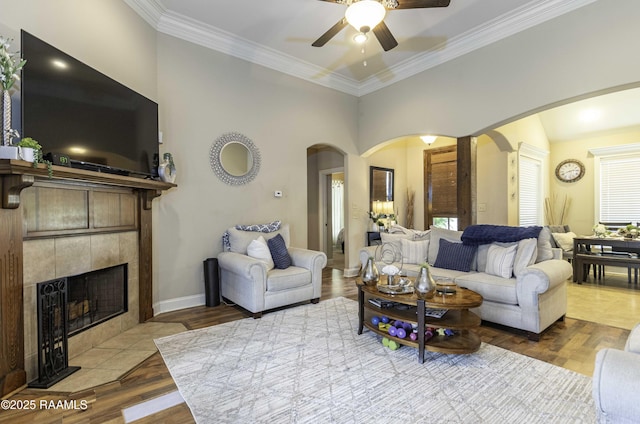 100 Mirada Ln, Lafayette, LA 70508 - living area featuring arched walkways, a ceiling fan, ornamental molding, a tiled fireplace, and wood finished floors