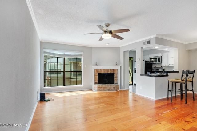 1304 E Bayou Pkwy Unit 4A, Lafayette, LA 70508 - living room featuring crown molding, a ceiling fan, light wood-style floors, a textured ceiling, and baseboards