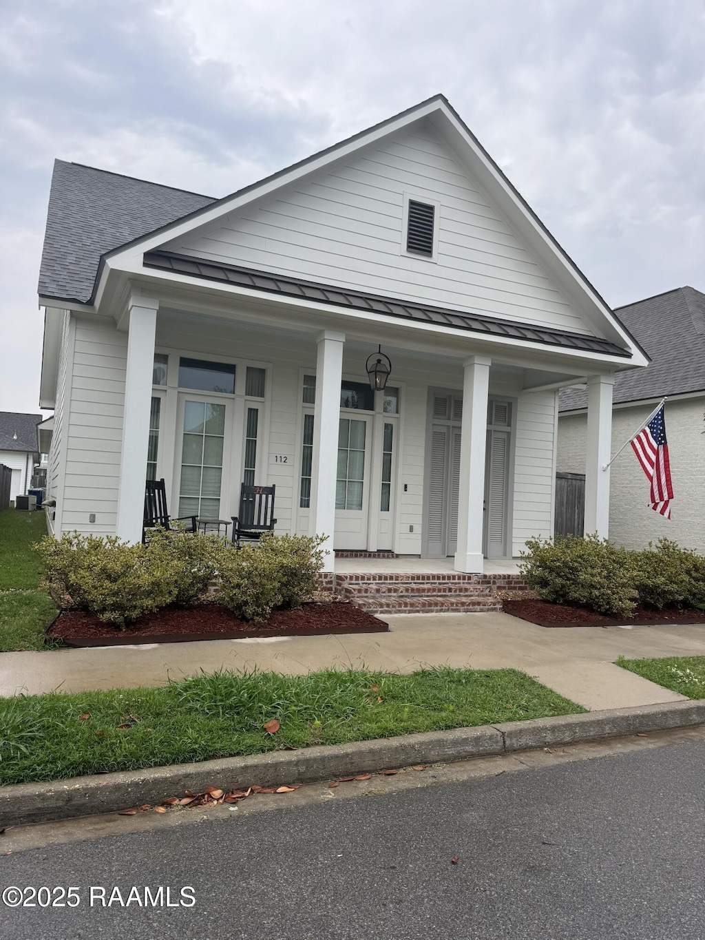112 San Juan Ln, Youngsville, LA 70592 - view of front of property with a standing seam roof, a porch, metal roof, and a shingled roof