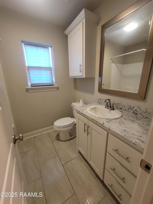313 Harvest Ln, Abbeville, LA 70510 - bathroom with vanity, toilet, and baseboards