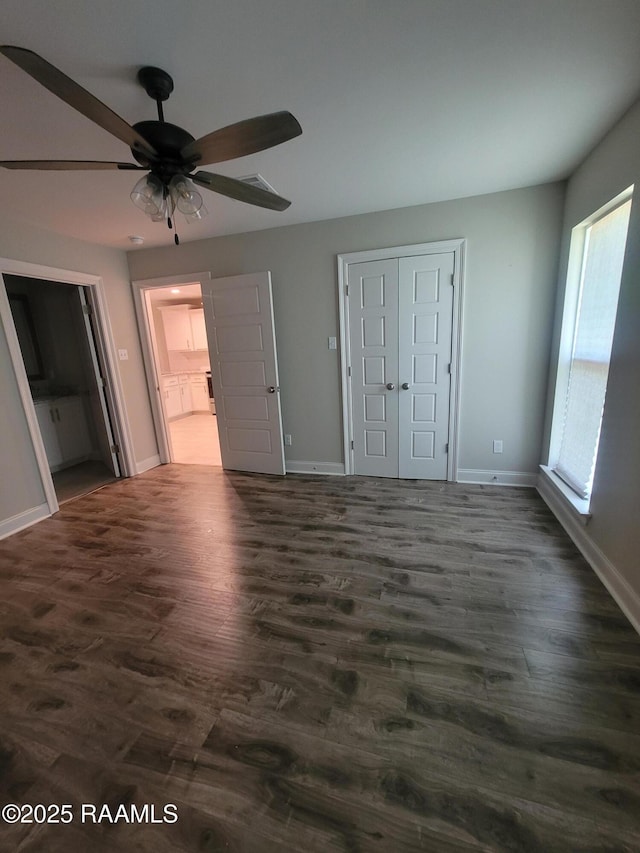 313 Harvest Ln, Abbeville, LA 70510 - unfurnished bedroom featuring baseboards, dark wood finished floors, a closet, and ensuite bath