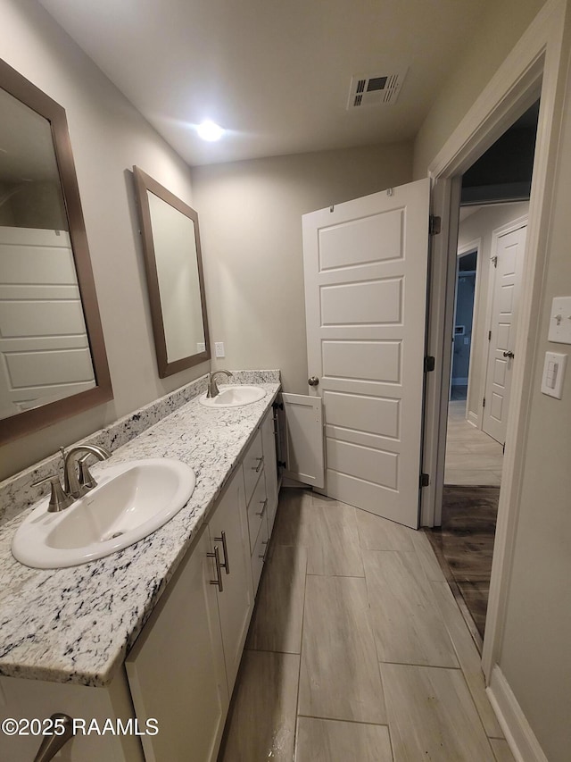 313 Harvest Ln, Abbeville, LA 70510 - bathroom with double vanity and wood finished floors