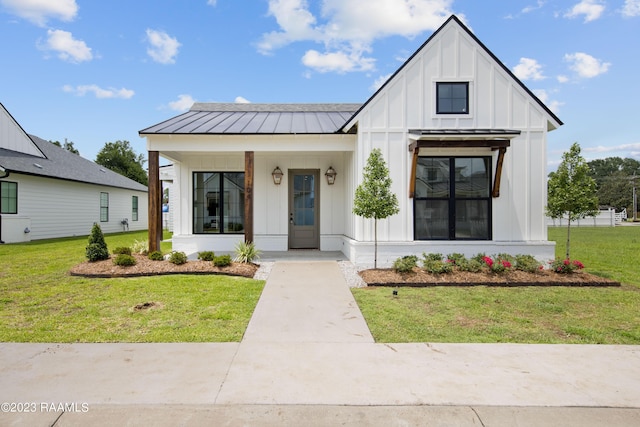 104 Wishing Well Dr, Broussard, LA 70518 - modern farmhouse featuring board and batten siding, covered porch, a front lawn, and a standing seam roof