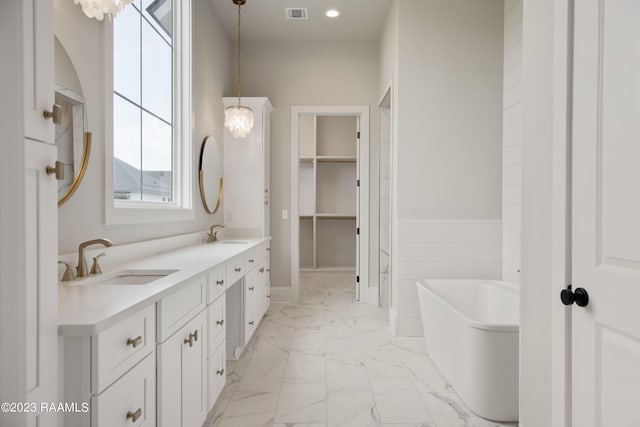 104 Wishing Well Dr, Broussard, LA 70518 - full bathroom with marble finish floors, a freestanding bath, double vanity, a spacious closet, and a chandelier
