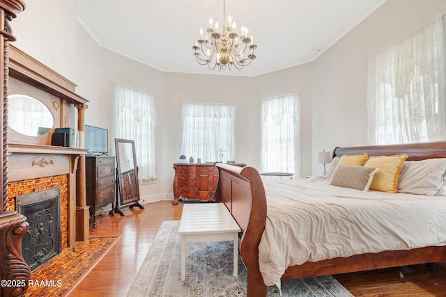 307 N Market St, Opelousas, LA 70570 - bedroom with a chandelier, crown molding, light wood-style floors, baseboards, and a fireplace