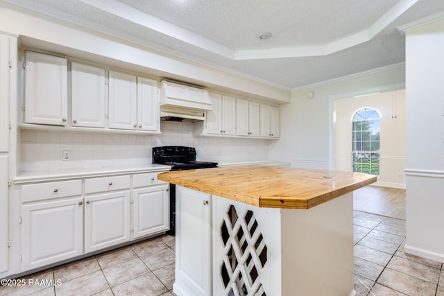421 Plantation Rd, Opelousas, LA 70570 - kitchen with premium range hood, light tile patterned floors, white cabinets, wooden counters, and crown molding