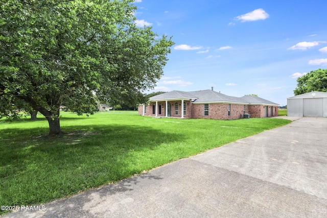 421 Plantation Rd, Opelousas, LA 70570 - view of front of house featuring an outbuilding, a porch, a front yard, and brick siding
