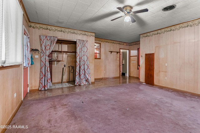 423 E 1st St, Jennings, LA 70546 - spare room featuring baseboards, a ceiling fan, healthy amount of natural light, wooden walls, and crown molding