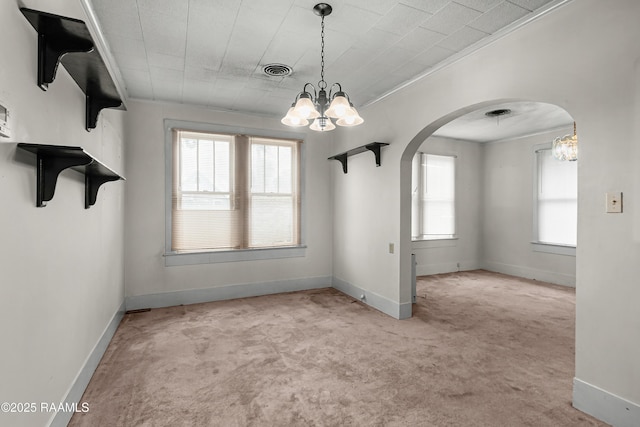 423 E 1st St, Jennings, LA 70546 - unfurnished dining area featuring a chandelier, carpet floors, arched walkways, baseboards, and crown molding