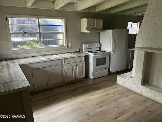 113 Fred St, Lafayette, LA 70501 - kitchen featuring white appliances, beamed ceiling, a sink, light countertops, and light wood-type flooring