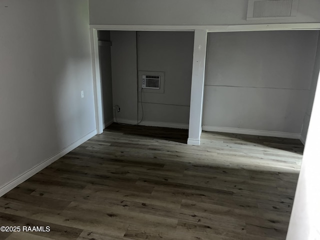 113 Fred St, Lafayette, LA 70501 - unfurnished bedroom featuring wood finished floors, a wall mounted AC, and baseboards